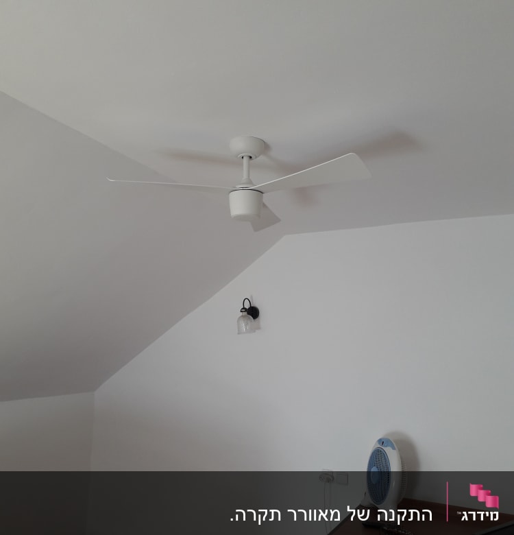 מאוורר תקרה לבן מותקן על תקרה משופעת